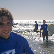 Surfistas felices después de la clase de surf Caras sonrientes después de un día exitoso de clases de surf en Fuerteventura – olas, sol y la alegría de aprender a surfear.