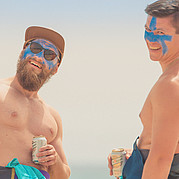 Caras felices después de las primeras olas de espuma En nuestro curso de surf para principiantes en Fuerteventura conoces gente nueva y compartes las primeras olas – aprender a surfear juntos es aún más divertido.
