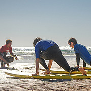 Primeros pasos en el curso de surf OTRO MODO Junto con el grupo haces tus primeras experiencias sobre la tabla – aprender a surfear en Fuerteventura es más fácil en equipo.