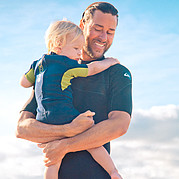 Mamá está surfeando, papá está vigilando al niño Mamá está surfeando, papá está vigilando al niño