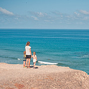 Familia con niños pequeños en la playa de surf Familia con niños pequeños en la playa de surf